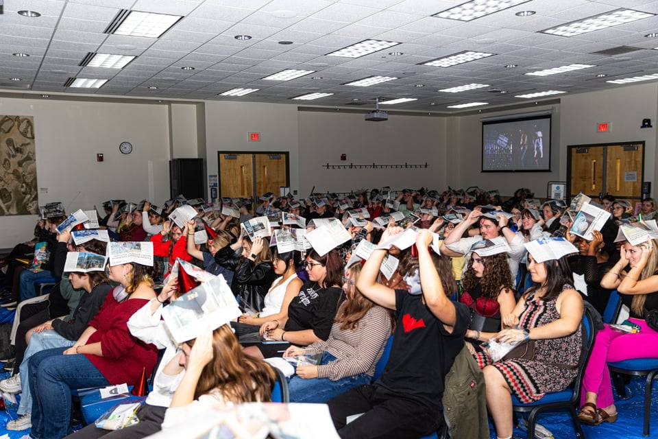 Students with papers over their heads